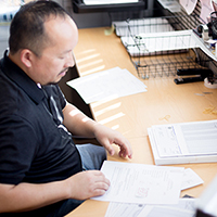 "man working through paperwork at his desk"