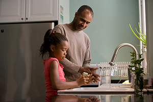 daughter and father washing dishes together