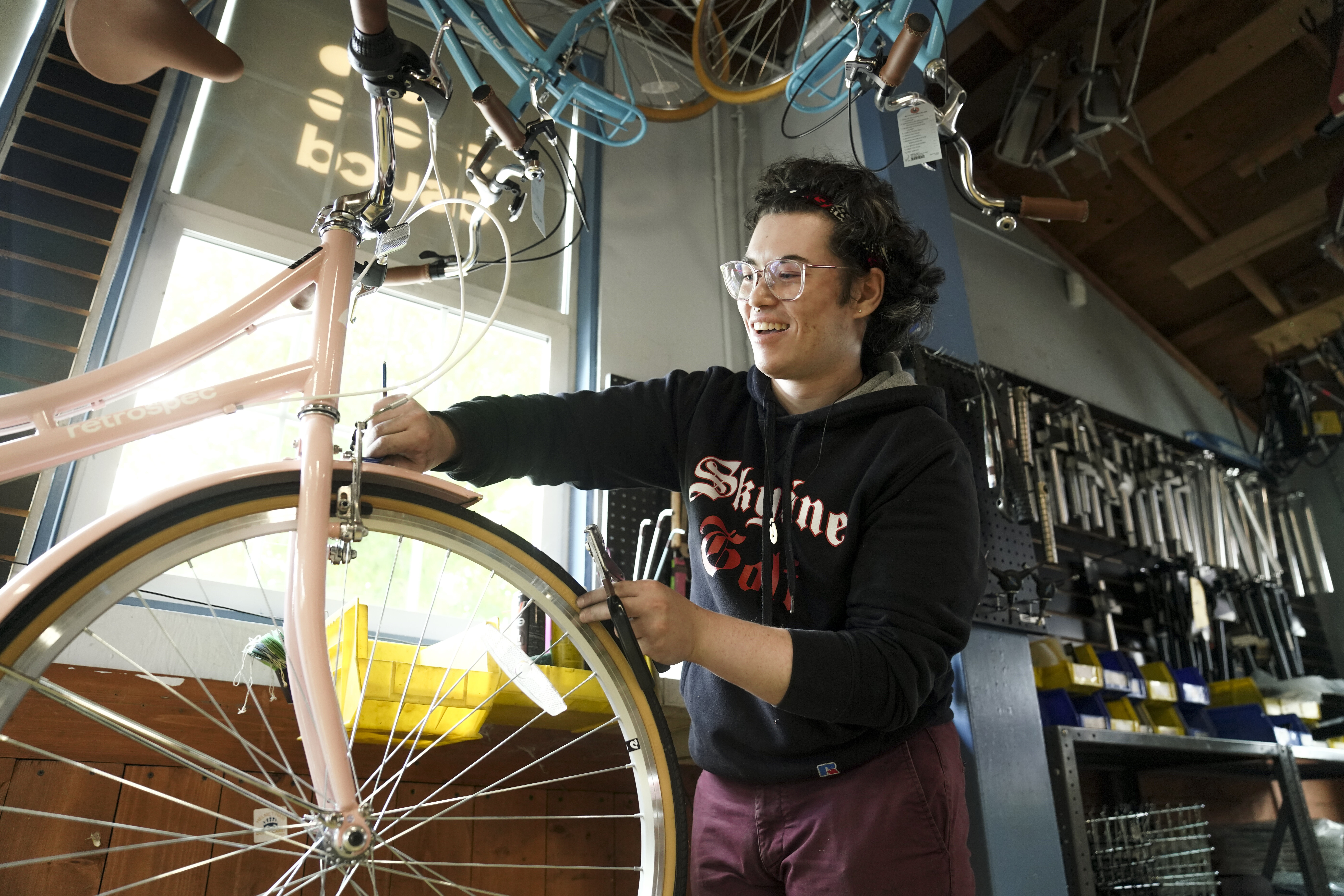 A student employee at the Bike Barn works on a bike.