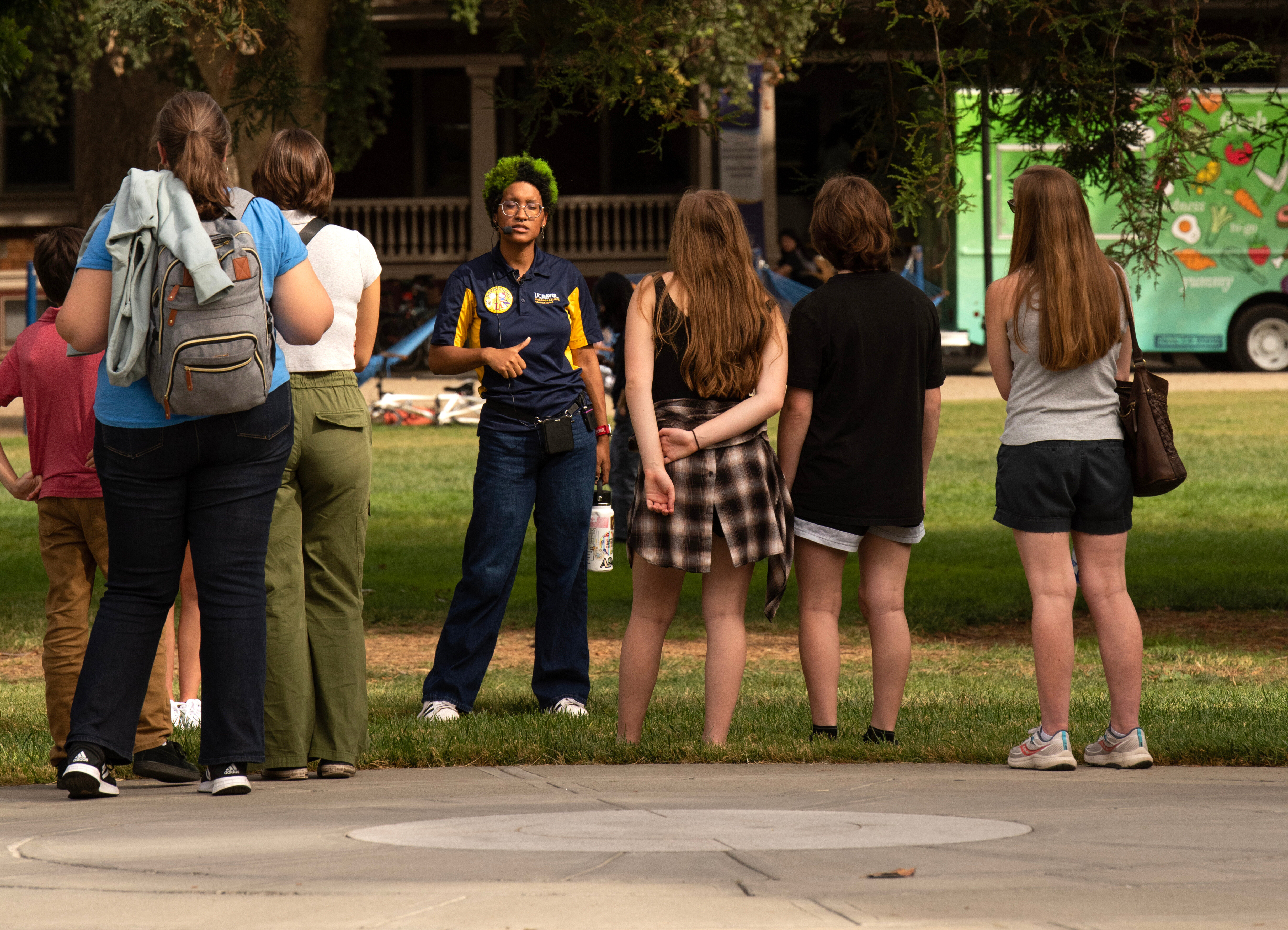 A student tour guide employee gives a tour through campus.