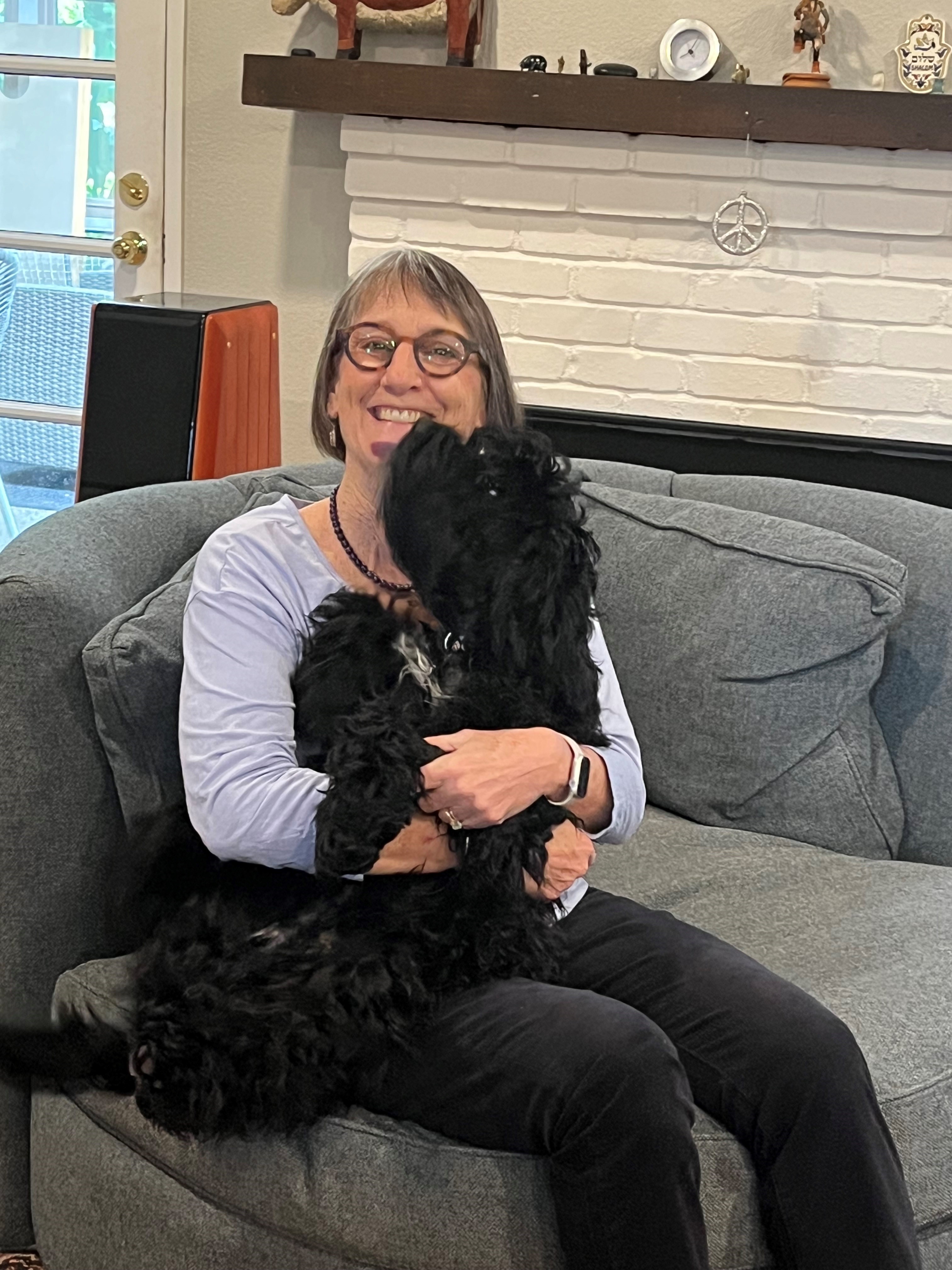 Carol on dog, Quincy, on her swivel chair.