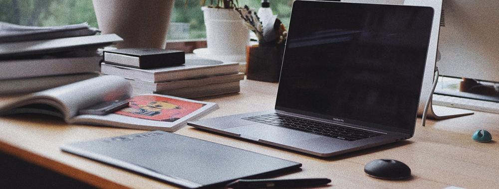 Black laptop computer on brown wooden table