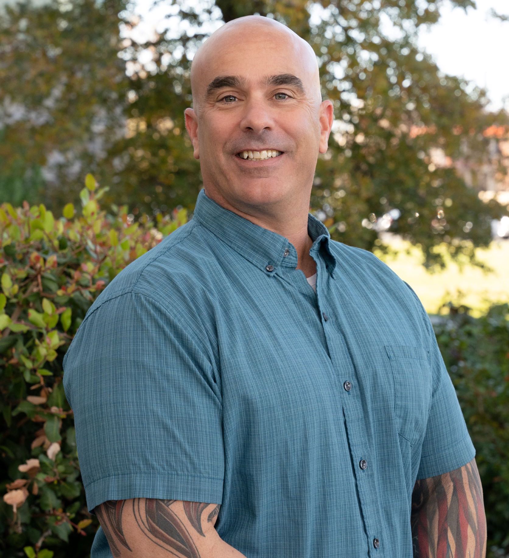 man standing in front of greenery