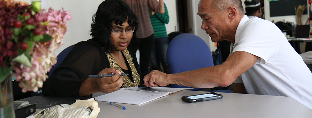 man helping a woman complete a form