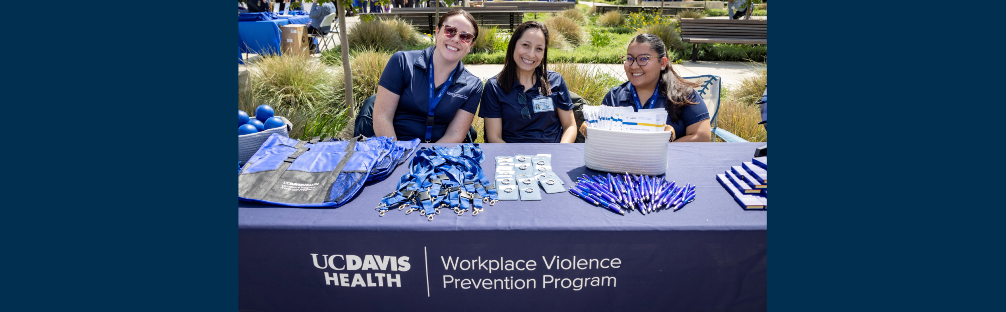 three employees sitting at workplace violence prevention booth
