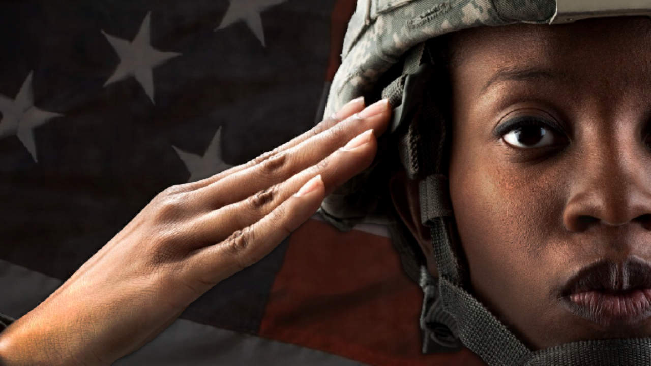female soldier saluting in front of an american flag
