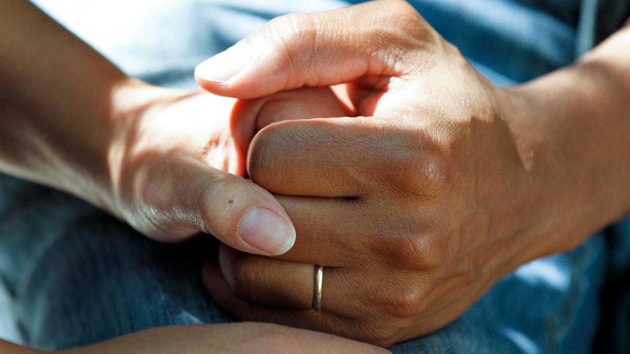 two pairs of hands holding each other in support