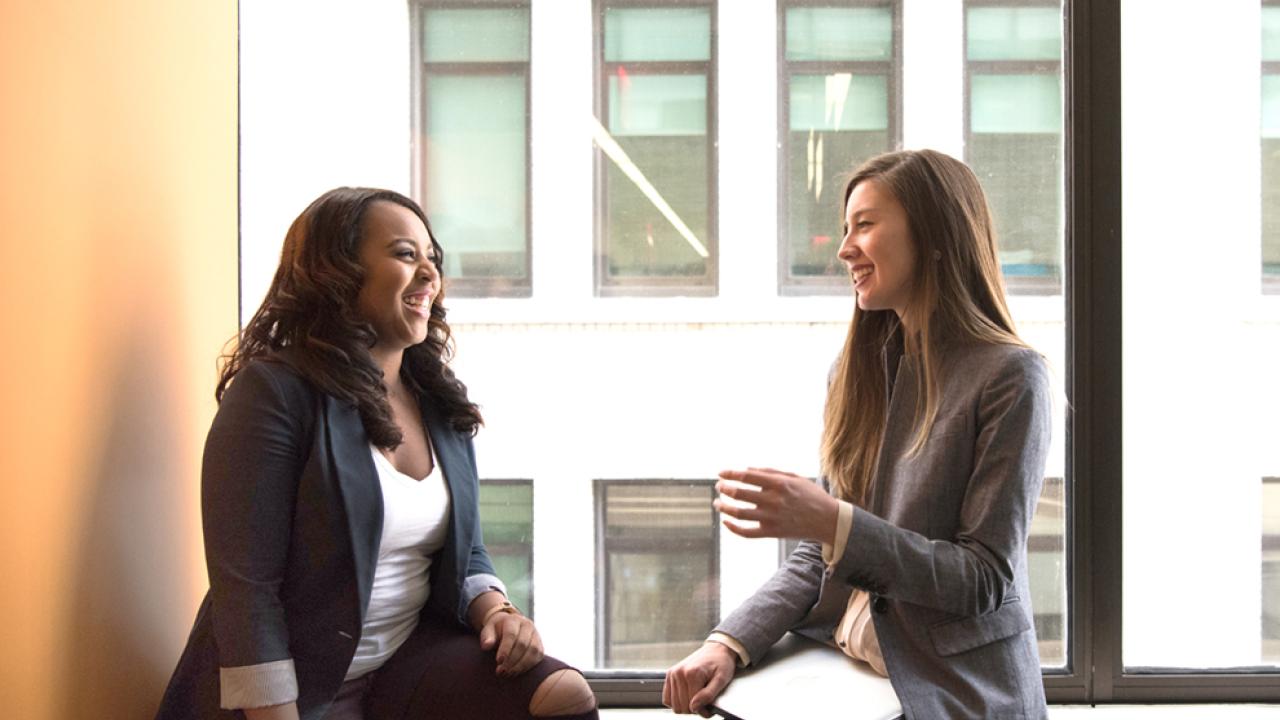 daytime employees talking by window