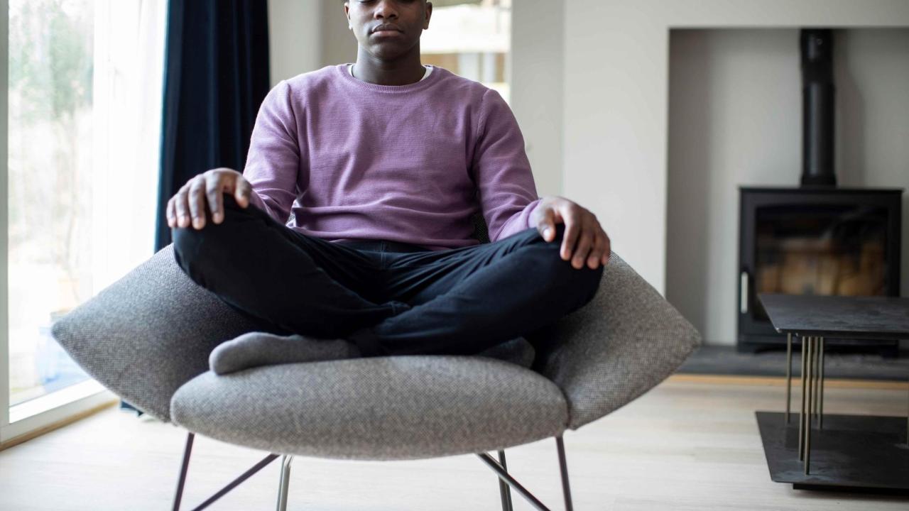 Man is sitting in a chair meditating.