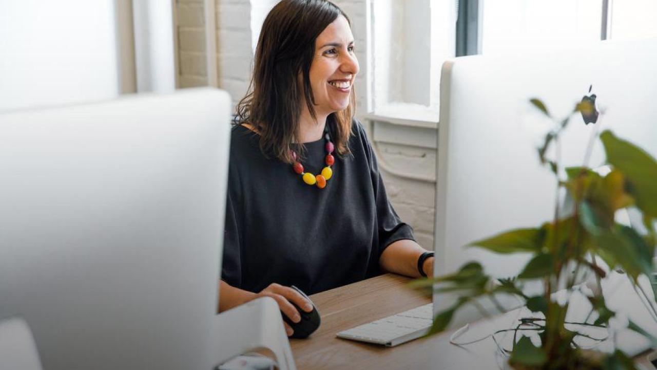 Photo of person using a desktop computer.