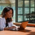 Woman viewing her laptop at a table