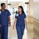 Two registered nurses walking side by side down the hallway